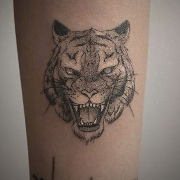 black and white tattoo of a tiger snarling