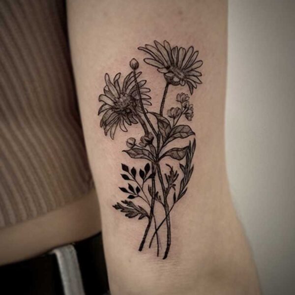 black and grey tattoo of daisies and foliage