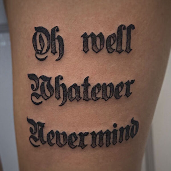black and grey text tattoo of the words "oh well nevermind"