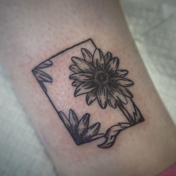 black and grey tattoo of sunflowers in a frame
