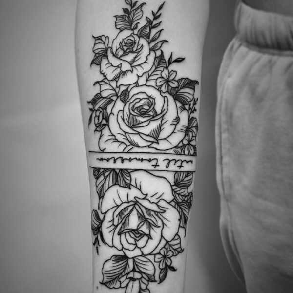 black and white tattoo of roses and foliage
