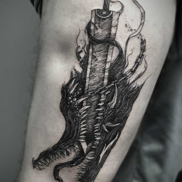 atticus tattoo, black and white tattoo of monsters head with a sword in its mouth