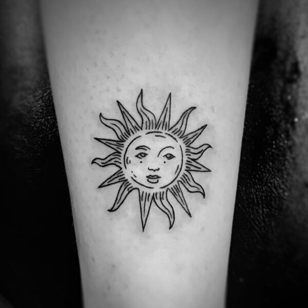 black and white tattoo of the sun