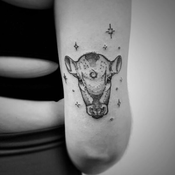 black and white tattoo of a cows face with sparkles