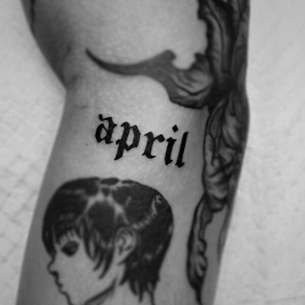 black font tattoo of the word april