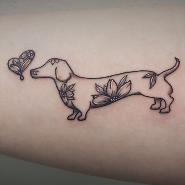 black and white tattoo of a dog with flowers and a butterfly