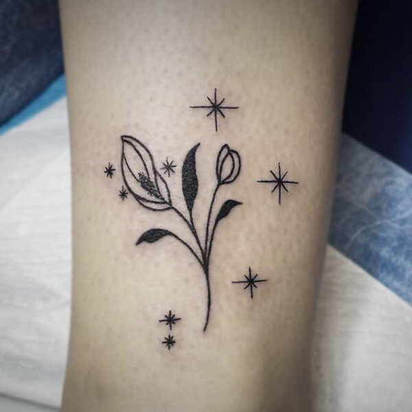 fine line tattoo of a lily and sparkles