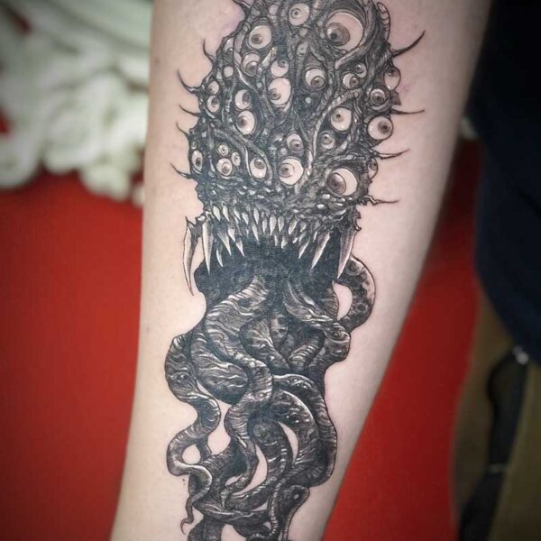 atticus tattoo, black and grey tentacle monster with several eyes