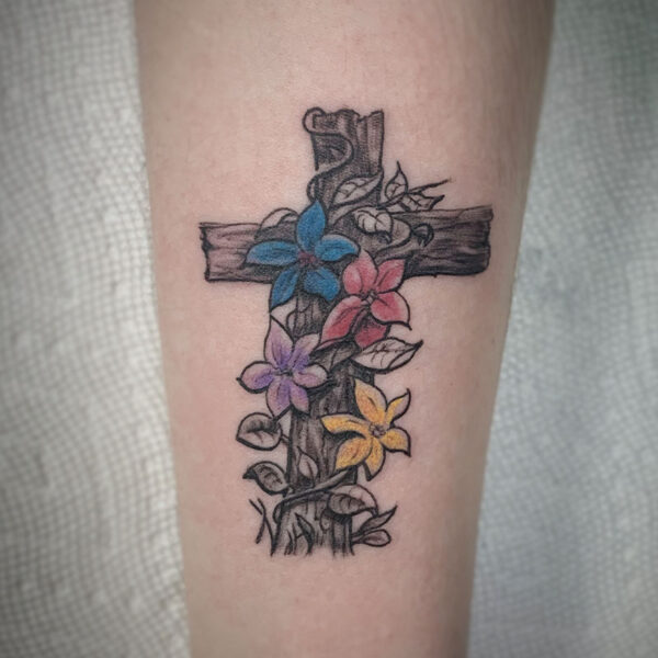 atticus tattoo, coloured tattoo of a cross with flowers