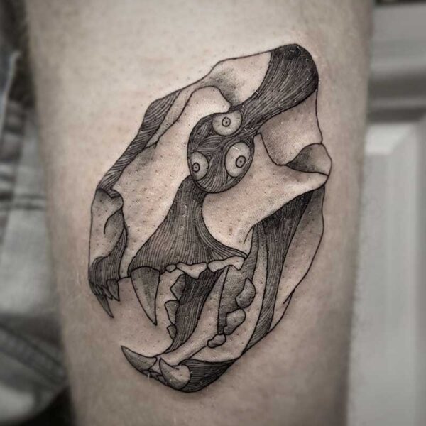 atticus tattoo, black and grey tattoo of a bear skull with exposed muscle