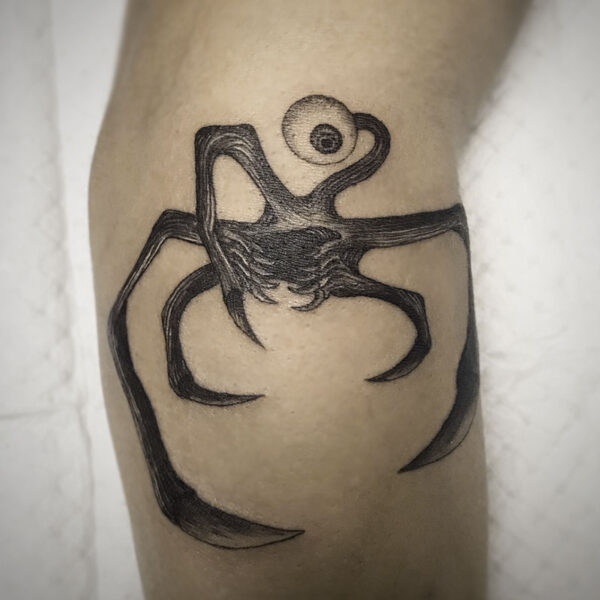 atticus tattoo, black and grey tattoo of a monster with one eye and several arms