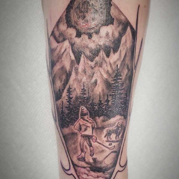 atticus tattoo, black and grey tattoo of a mountain scene framed by antlers