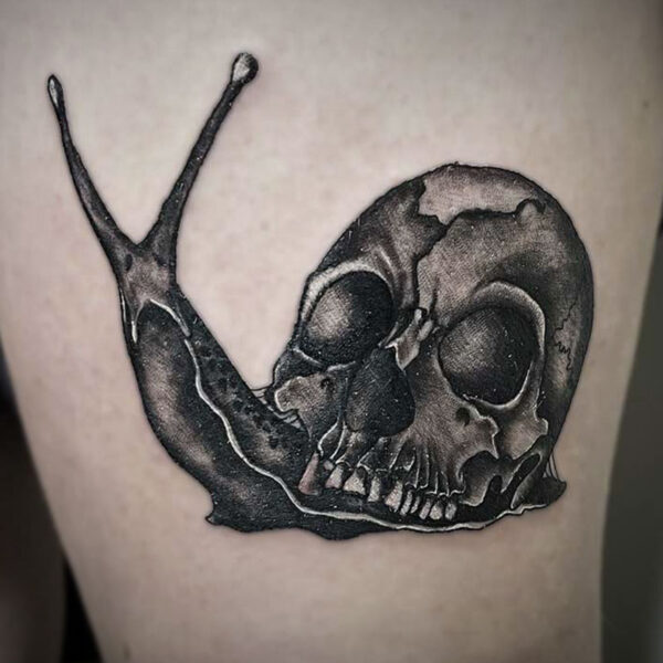 black and white tattoo of a snail with a skull for the shell