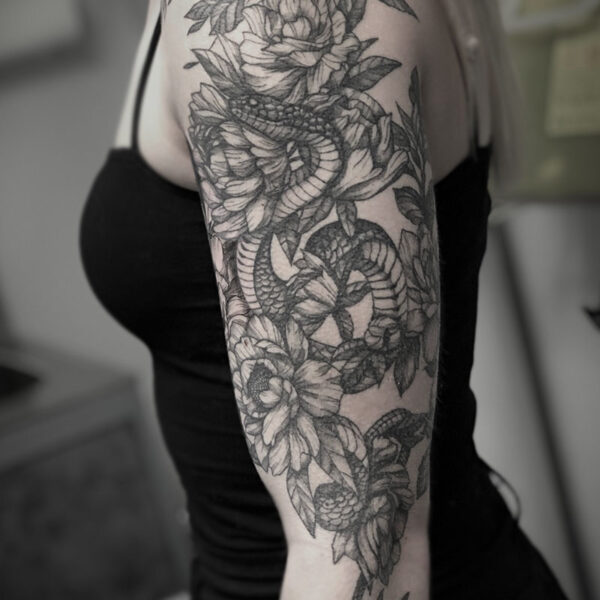 atticus tattoo, black and white realistic tattoo of a snake among flowers and foliage
