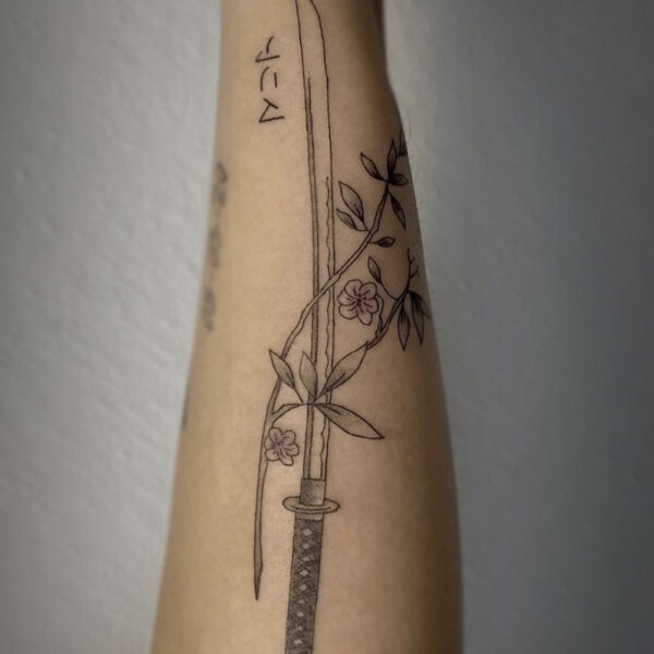 atticus tattoo, black and grey tattoo of a katana with flowers