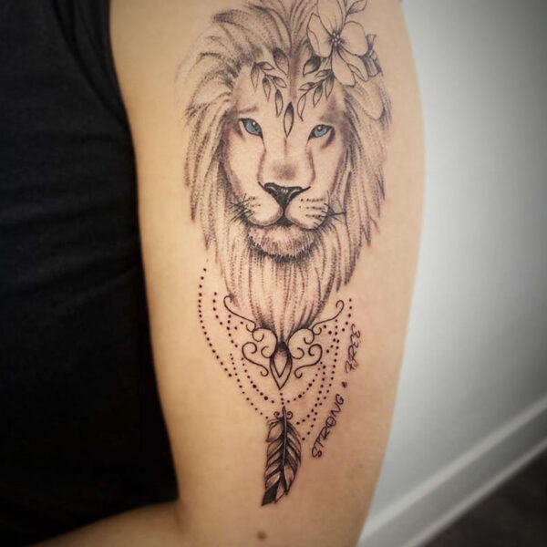atticus tattoo, black and grey tattoo of a lion with flowers in its mane