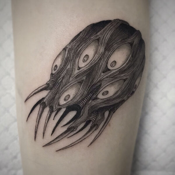 atticus tattoo, black and grey tattoo of a monster with spiky legs and five eyes