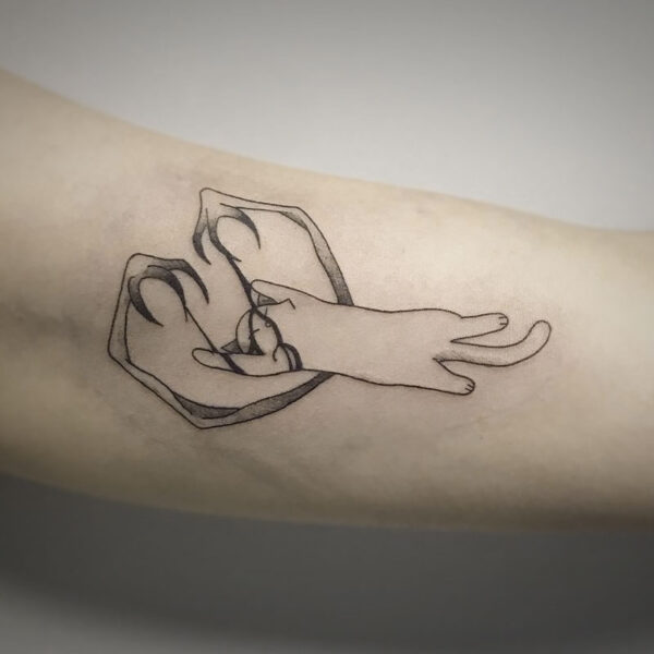 atticus tattoo, line tattoo of a cat lying on the ground playing with monster arms