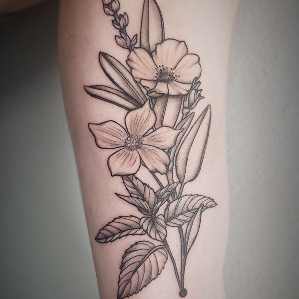 atticus tattoo, black and grey tattoo of flowers and stems of leaves