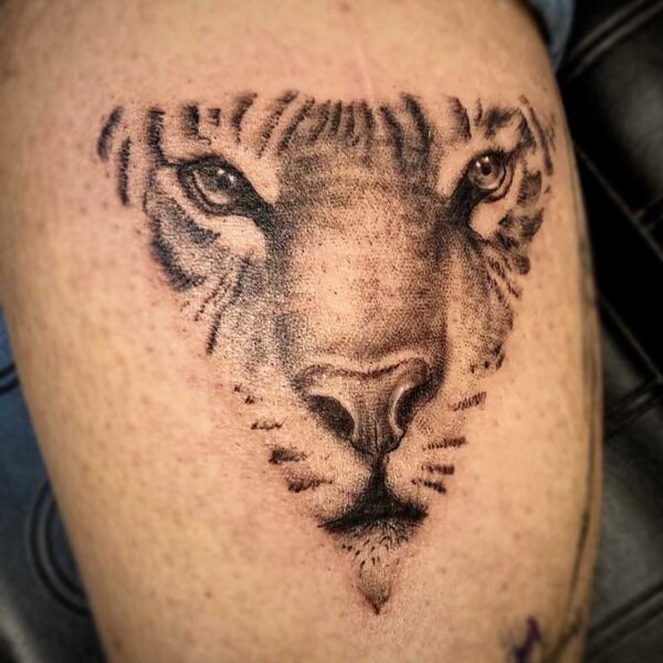 atticus tattoo, pointillism tattoo of a tigers face in a triangle