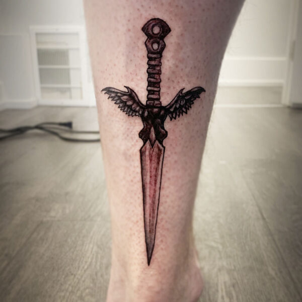 atticus tattoo, black and grey tattoo of a dagger with wings