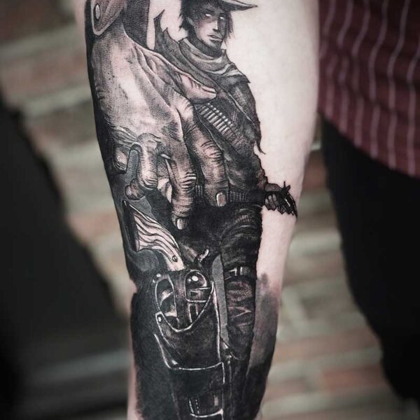 atticus tattoo, black and grey tattoo of a man's hand gripping a gun and a gunslinger in the background