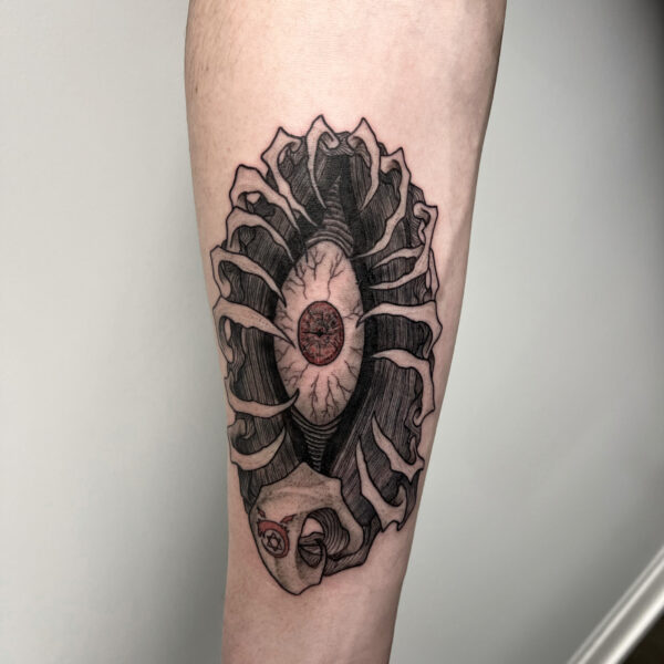 atticus tattoo, black and grey tattoo of a monster eyeball with a red pupil