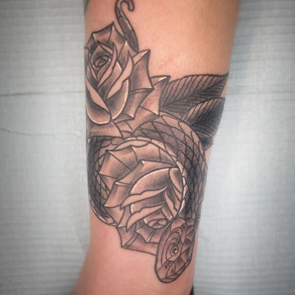 atticus tattoo, black and grey neotraditional tattoo of a snake with roses