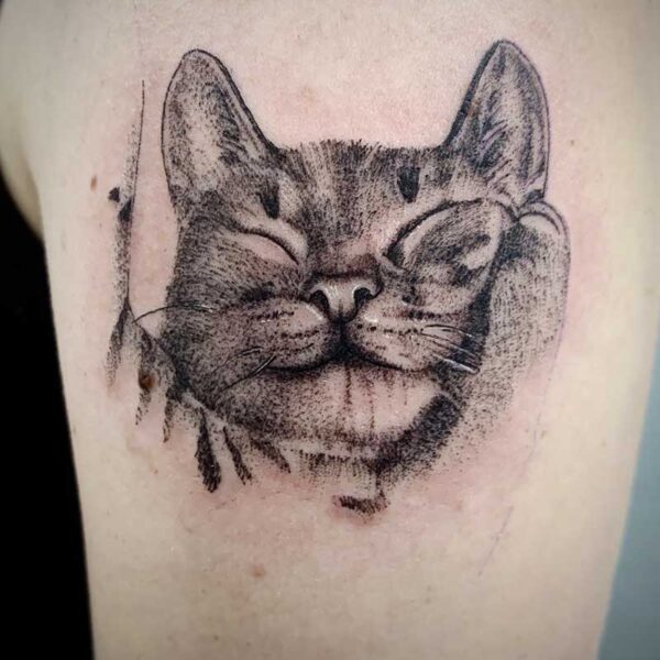 atticus tattoo, black and grey tattoo of a tabby cat that is sleeping