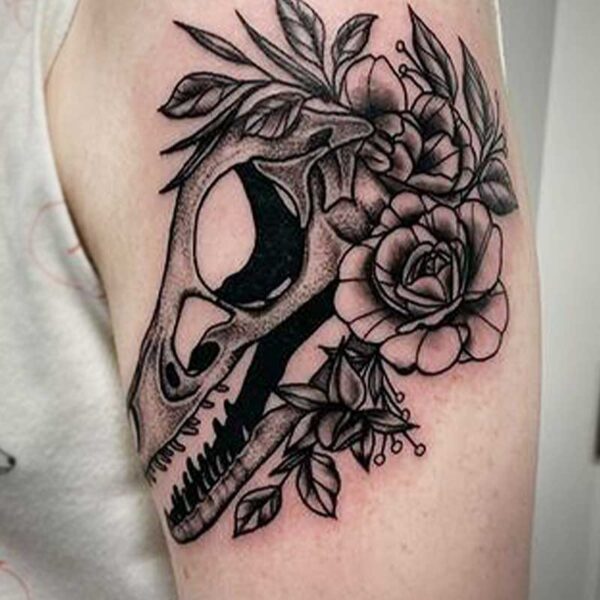 atticus tattoo, black and grey tattoo of a dinosaur skull with flowers