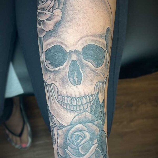 atticus tattoo, black and grey realism tattoo of a skull with roses