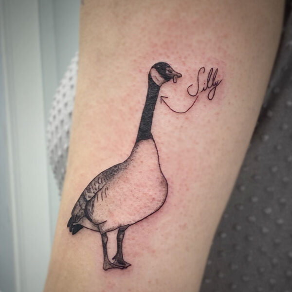atticus tattoo, black and grey tattoo of a Canadian goose with its tongue sticking out and the word "silly"