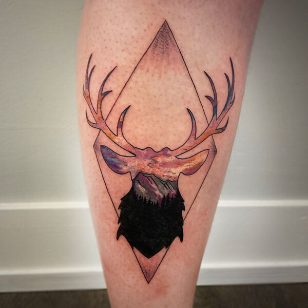 atticus tattoo, coloured tattoo of a deer silhouette with a mountain scene on it