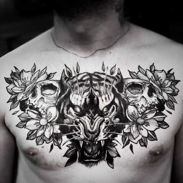 atticus tattoo, black and grey tattoo of a tiger snarling and two skulls and flowers on either side of the tiger