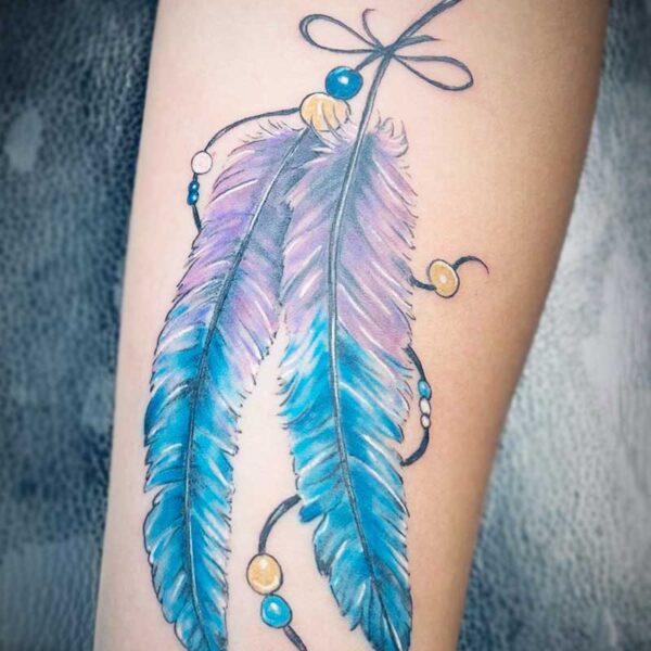 atticus tattoom, coloured tattoo of two feathers with string and beads