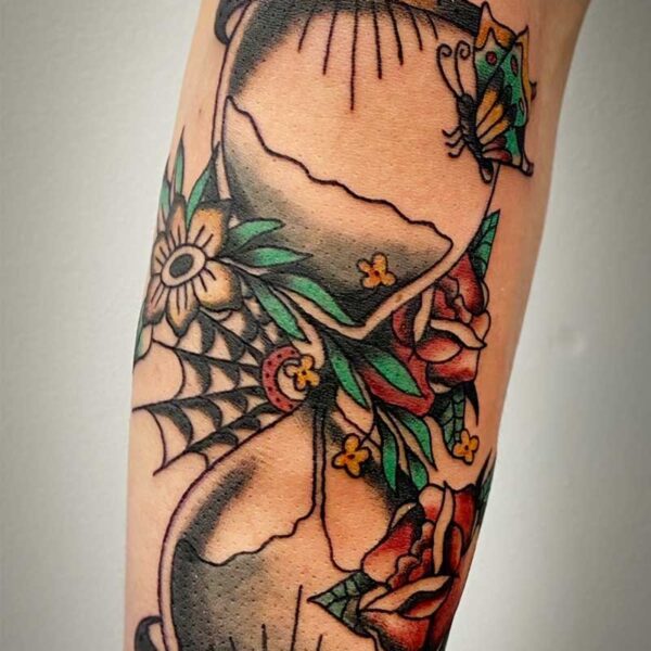 atticus tattoo, coloured traditional tattoo of an hour glass with flowers and spider webs