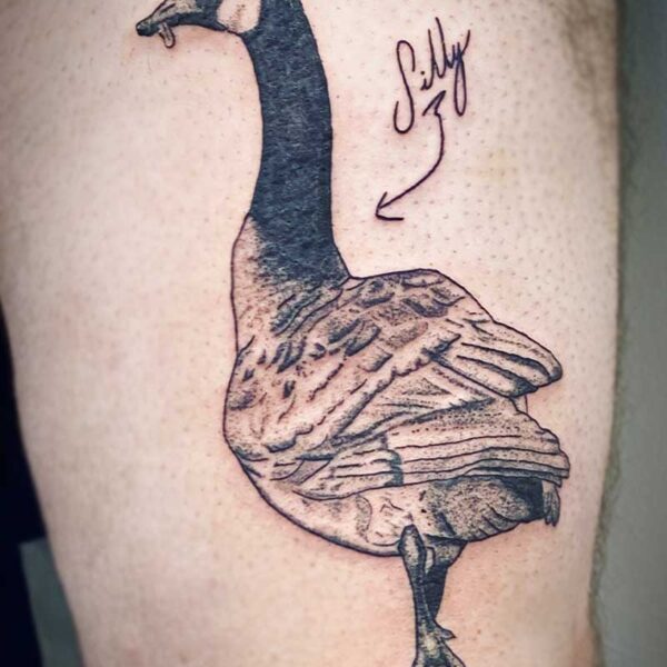 atticus tattoo, black and grey tattoo of a Canadian goose with the word silly