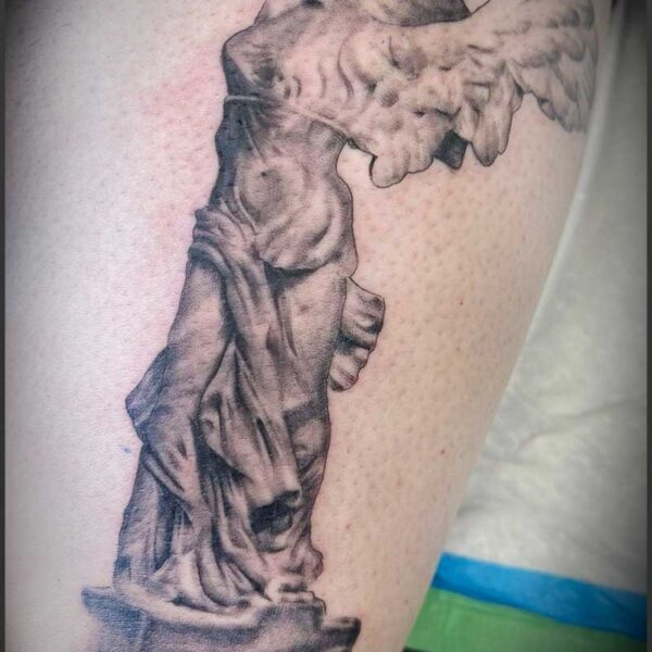 atticus tattoo, black and grey realism tattoo of a statue with wings