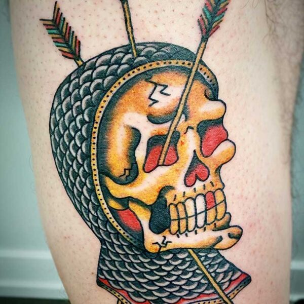 atticus tattoo, coloured traditional tattoo of skull wearing chainmail and arrows going through it