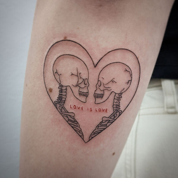 atticus tattoo, fine line tattoo of two skeletons in a heart with the words "love is love"
