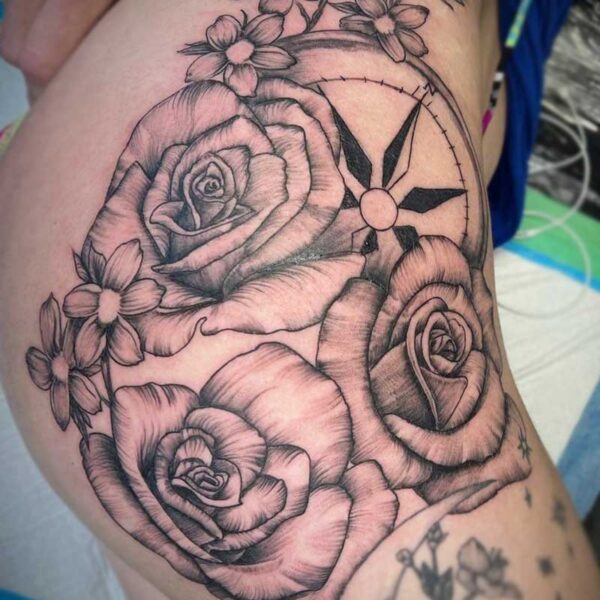 atticus tattoo, black and grey tattoo of roses, small flowers and a compass