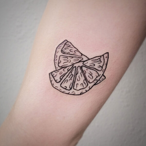 atticus tattoo, black and grey tattoo of two slices of a lemon