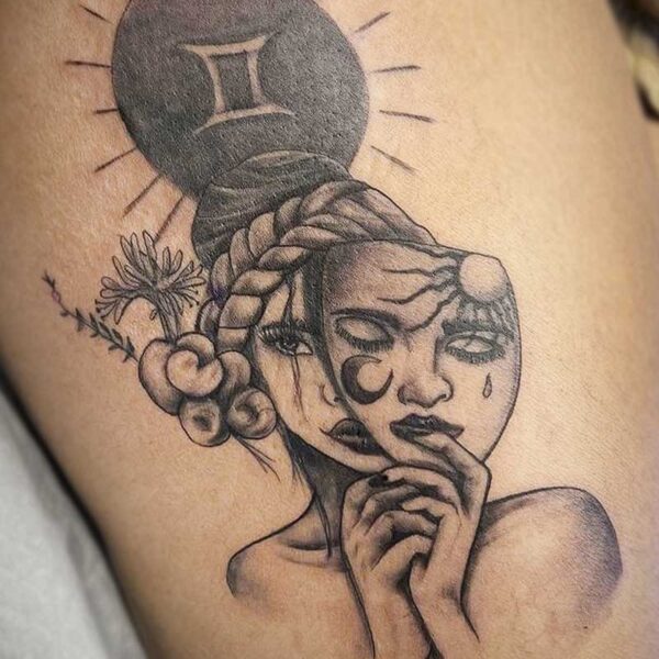 atticus tattoo, black and grey tattoo of a woman taking off a mask and the gemini symbol above her head