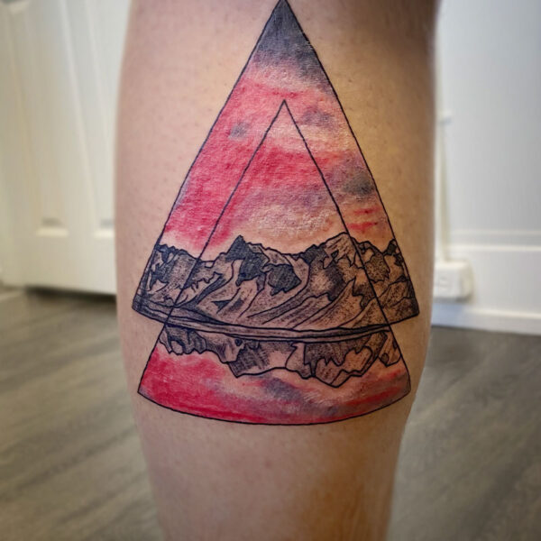 atticus tattoo, coloured tattoo of a mountain range and sunset in two triangles