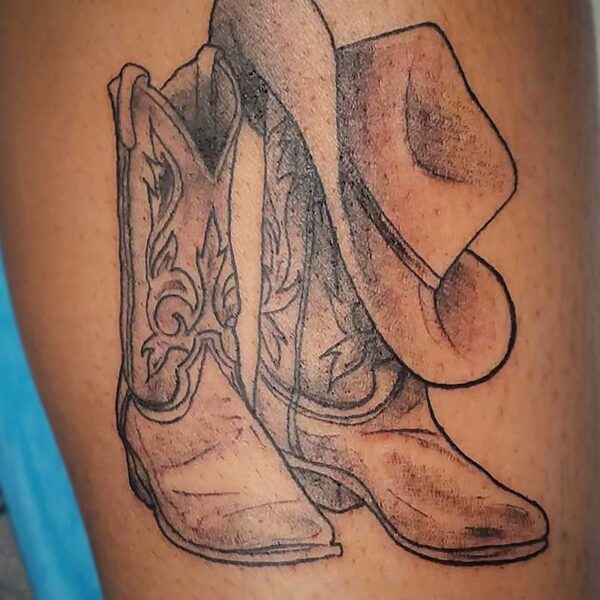 atticus tattoo, black and grey tattoo of cowboy boots and hat
