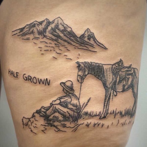 atticus tattoo, black and grey tattoo of a cowboy with a horse overlooking a mountain range