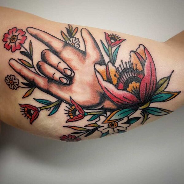 atticus tattoo, coloured, american traditional tattoo of a hand and flowers