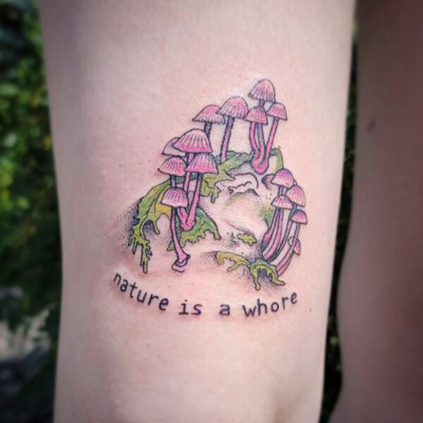 atticus tattoo, tattoo of pink mushrooms on grass with the words "nature is a whore"