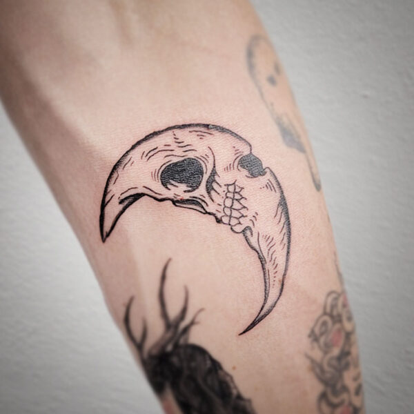 atticus tattoo, black and grey tattoo of a crescent moon with a skull face