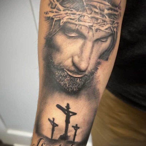 atticus tattoo, black and grey portrait tattoo of Jesus overlooking crosses